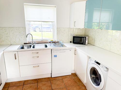 a kitchen with a sink and a washing machine at Brittas Bay Holiday Village No 7 by Trident Holiday Homes in Brittas Bay