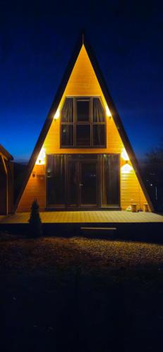 una casa con luces en la parte delantera de la noche en E&T-Cabin A frame, en Sibiu