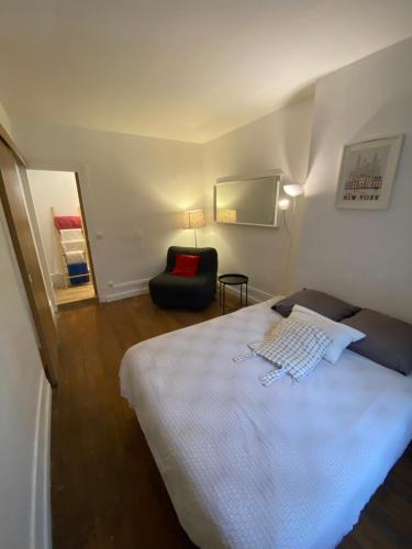 une chambre avec un lit blanc et une chaise dans l'établissement Abesse Appart, à Paris
