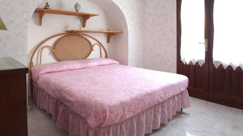 a bedroom with a bed with a pink blanket at Sea View, Nature & BBQ - Historic "Dammusi" in Pantelleria