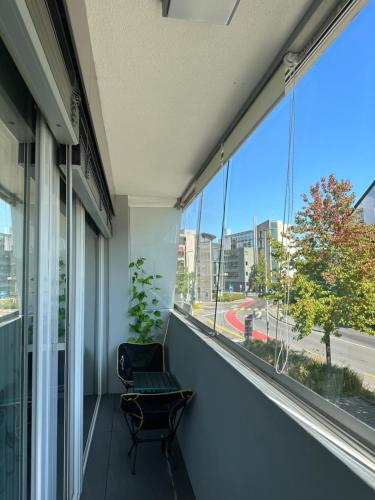 a balcony with a chair and a large window at Charme mystique de la Chine, Free Parking in Morges