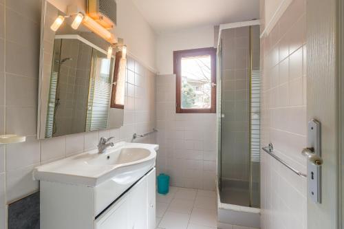 une salle de bain blanche avec un lavabo et une douche dans l'établissement La Petra Marinella - Appt climatisé avec piscine, à LʼÎle-Rousse