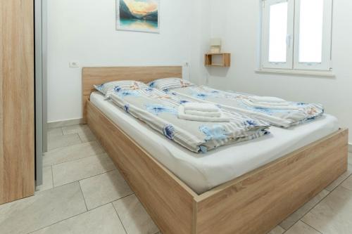 uma cama com uma estrutura de madeira num quarto em Apartmaji Ema em Koper