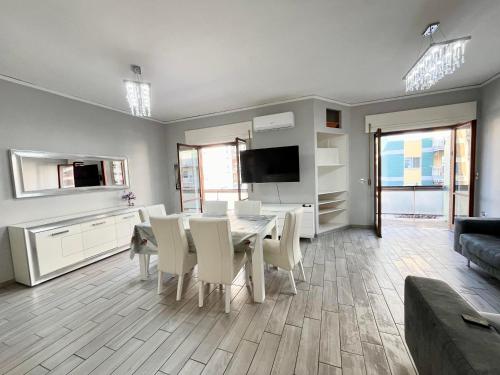 een woonkamer met een tafel en stoelen en een televisie bij Greta's Apartment in San Giorgio a Cremano
