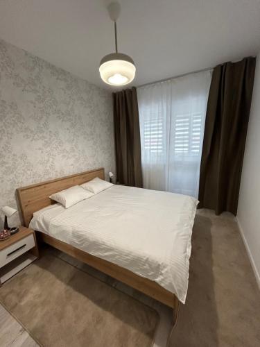 a bedroom with a white bed and a window at Silvia House in Chiajna