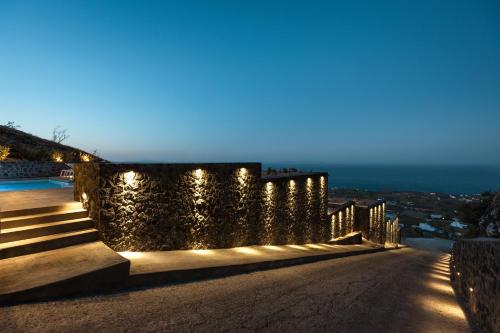 a house with lights on the side of a wall at Almarossa Luxury Villas in Vourvoulos
