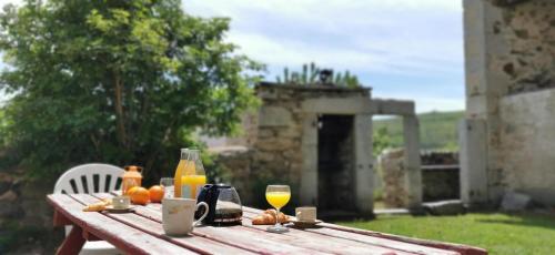una mesa de madera con naranjas y vasos de zumo de naranja en Gîte Camporells, en Dorres