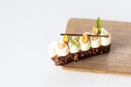 a chocolate dessert with marshmallows and nuts on a wooden board at Hotel Weisses Kreuz in Malles Venosta