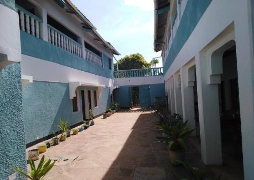 a courtyard of a blue and white building with potted plants at Subira Guest House and Restaurant in Lamu