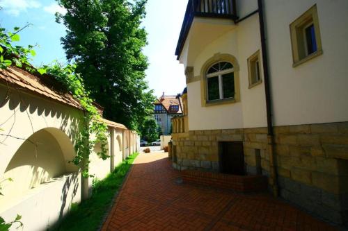 a building with a brick walkway next to a building at PAŁACYK BUDGET in Legnica