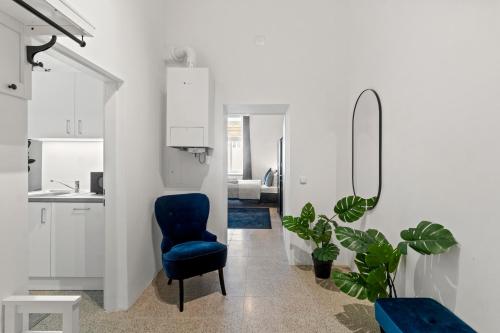 uma sala de estar com uma cadeira azul e uma casa de banho em Stylish Apartment, 4 min to U3 Zipperer Straße em Viena