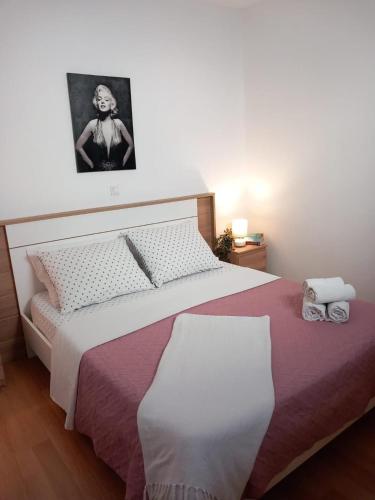 a bedroom with a bed and a picture of a woman at Apartments Pipi in Pakoštane