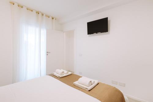 a white bedroom with a bed with towels on it at Marisabella Suite Spa 3 in Bari
