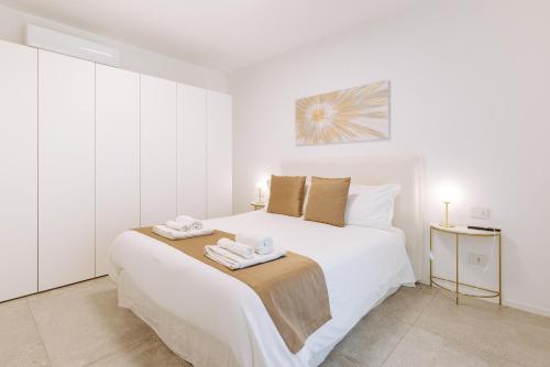 a bedroom with a large white bed with towels on it at Marisabella Suite Spa 3 in Bari
