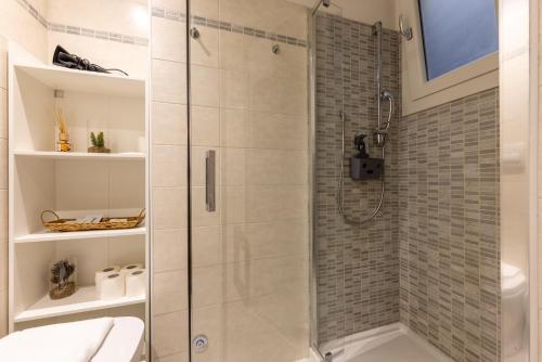 La salle de bains est pourvue d'une douche avec une porte en verre. dans l'établissement Cortivo House - Silva 45 next to metro Lotto, à Milan