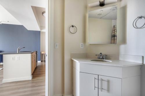 a white bathroom with a sink and a mirror at East Cambridge 1br w gym wd near T stop BOS-958 in Boston
