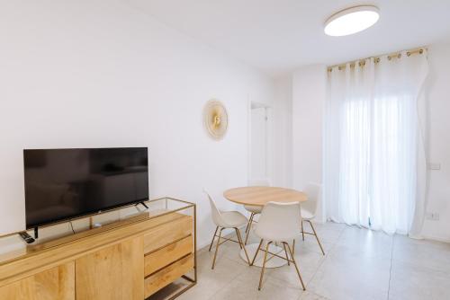 a living room with a table and a flat screen tv at Marisabella Suite Spa 3 in Bari