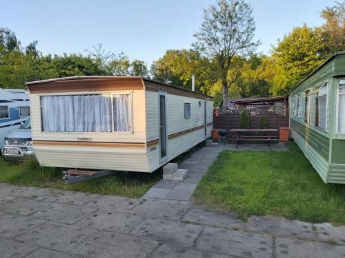 two mobile homes are parked in a yard at Domki holenderskie HEL in Hel