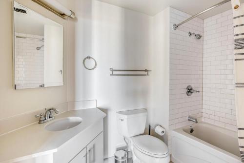a white bathroom with a sink and a toilet and a tub at East Cambridge 1br w gym wd near T stop BOS-959 in Boston