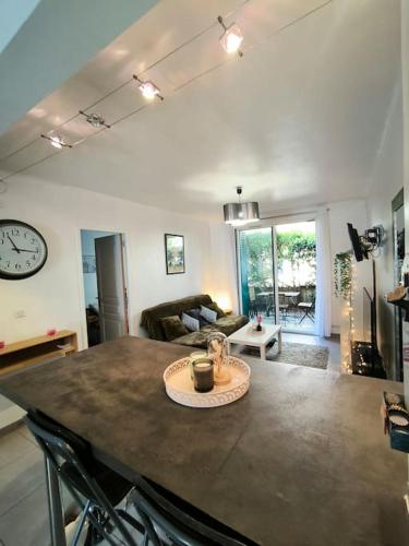 d'une cuisine et d'un salon avec une table et une horloge. dans l'établissement Le nid provençal, à Aix-en-Provence