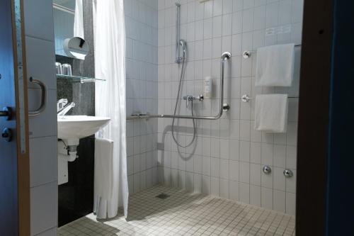a bathroom with a shower and a sink at Hotel Sempachersee in Nottwil
