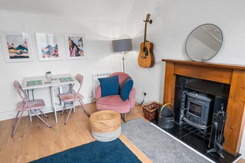a living room with a fireplace and a mirror at Beautiful 1 bedroom apartment with free on street parking in Oban