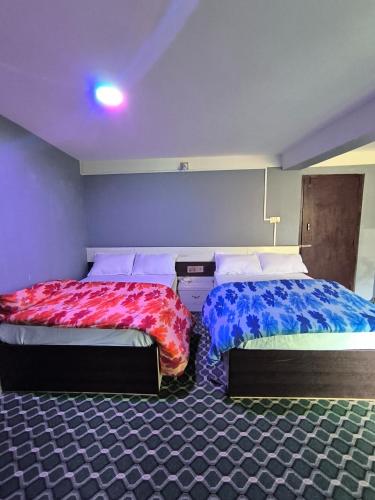 - deux lits assis l'un à côté de l'autre dans une pièce dans l'établissement HOTEL CENTRE POINT RESTAURANT & Lodge, à Tāplejung