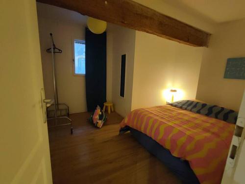 SeyssesにあるAppartement T2 - RDCのベッドルーム1室(ベッド1台付)、ランプが備わります。