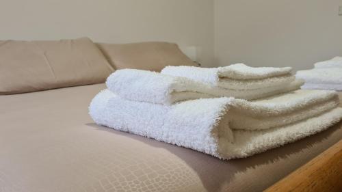 una pila de toallas blancas sentadas en un sofá en Albergo Meublé Aurora en Edolo