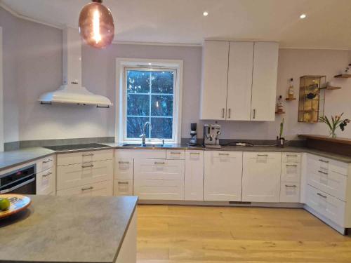 a large kitchen with white cabinets and a window at Gula Villan in Gothenburg