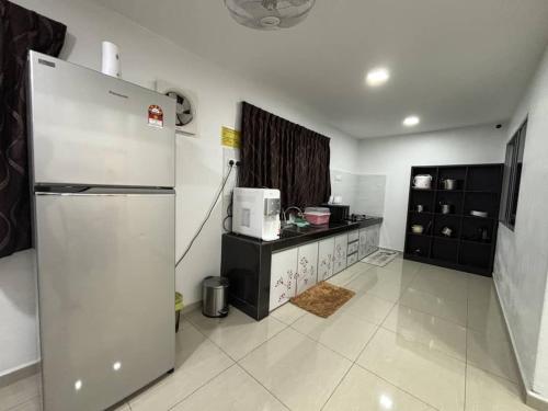 a kitchen with a refrigerator and a counter in it at 126 Homestay TYPE B in Tangkak