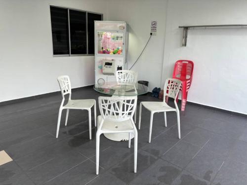 a table and chairs and a refrigerator in a room at 126 Homestay TYPE B in Tangkak