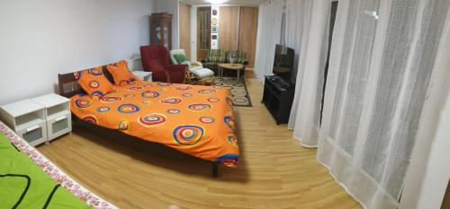 a bedroom with an orange bed and a living room at Casa Misha in Petreşti