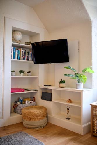 a living room with a flat screen tv on a wall at Charming Apt nr Centre - Terrace & Street Parking in Oban
