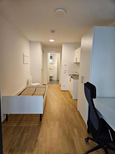a room with a bed and a desk and a kitchen at State of the Art in Nuremberg