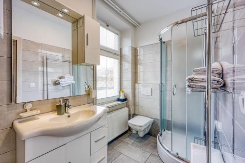 a bathroom with a sink and a shower and a toilet at Apartments Jantar - Happy Rentals in Novo Mesto