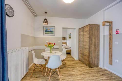 comedor con mesa y sillas blancas en Apartments Jantar - Happy Rentals en Novo Mesto