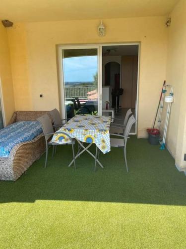 - une chambre avec une table, un lit et un balcon dans l'établissement T2 rez de villa avec piscines, à Fréjus