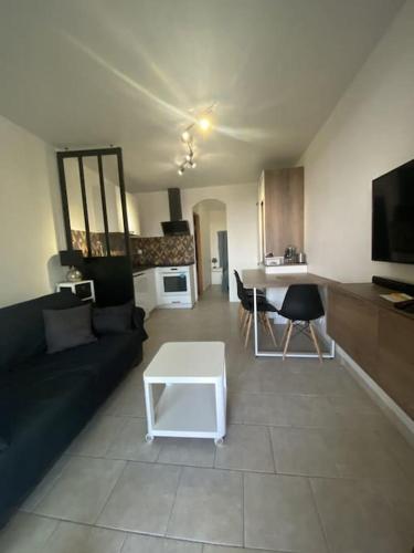 un salon avec un canapé et une table dans l'établissement T2 rez de villa avec piscines, à Fréjus