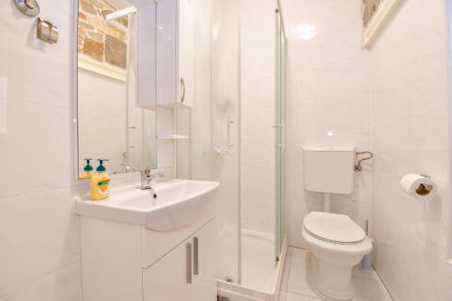 Baño blanco con lavabo y aseo en Casa Matošića Apartments, en Split