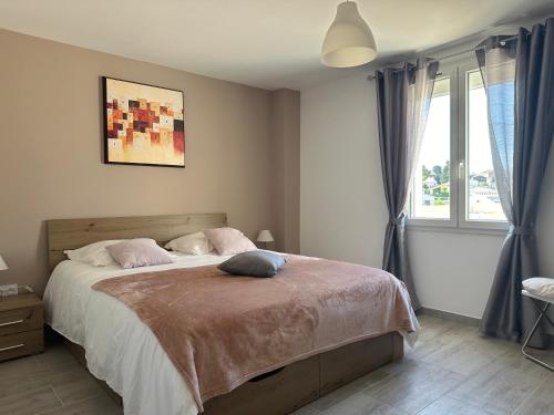 une chambre avec un grand lit avec des oreillers roses dans l'établissement Les Geckos de Mus, à Mus