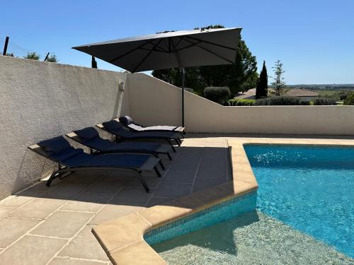 un groupe de chaises longues et un parasol à côté d'une piscine dans l'établissement Les Geckos de Mus, à Mus