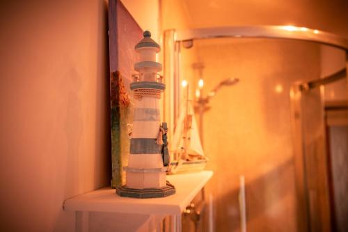 a lighthouse bottle sitting on a shelf in a bathroom at Pabbay House Self Catering in Back