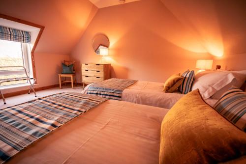 a bedroom with two beds and a window at Pabbay House Self Catering in Back