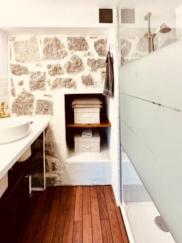 La salle de bains est pourvue d'un mur en pierre. dans l'établissement La cave marine du Trottel, à Ajaccio