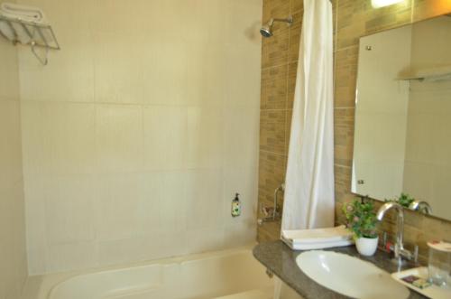 a bathroom with a tub and a sink and a shower at Cubbon Suites - 10 Minute walk to MG Road, MG Road Metro and Church Street in Bangalore