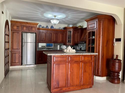 a kitchen with wooden cabinets and a stainless steel refrigerator at Maria's Entire House HIGUEY 2BD in Higuey