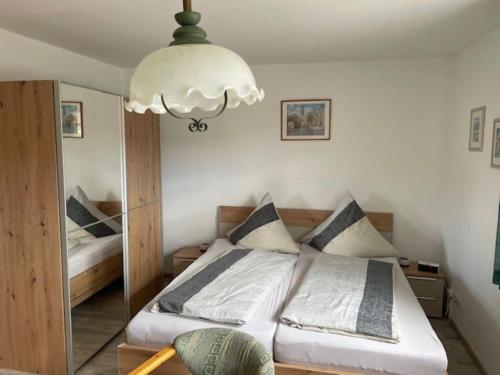 um quarto com uma cama e um lustre em Ferienwohnungen Müller em Bad Staffelstein
