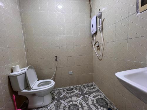 EASTERN PLAZA HOTEL في جوبا: حمام مع مرحاض وهاتف على الحائط