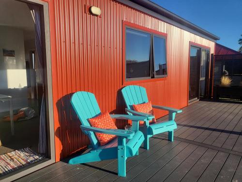 two chairs sitting on the deck of a house at Rough Ridge Cottage ~ your haven in Central Otago in Oturehua